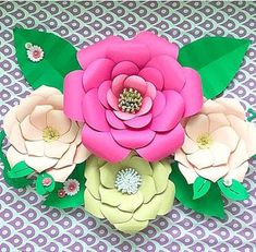 an arrangement of paper flowers sitting on top of a table