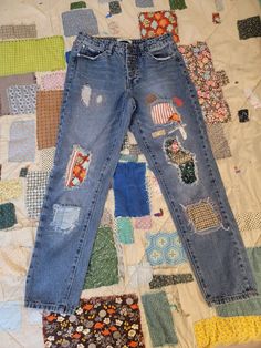 an old pair of jeans with patches on them are laying on a quilted surface