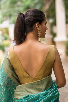 Bringing you yet another simple and striking blouse this month. In a trendy and timeless V neck style made out of a very versatile gold brocade. This is a wardrobe staple which will fast become your go-to blouse. Gold is truly a neutral colour. The entire box of crayons is your saree colour options for pairing this versatile number. Sleeveless Blouse Designs, House Of Blouse, Backless Blouse Designs, Blouse Back Neck Designs, Indian Saree Blouse, Elegant Blouse Designs