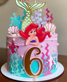 the little mermaid birthday cake is decorated with pink and blue icing