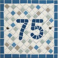 a blue and white mosaic tile with the number seventy seven on it's side