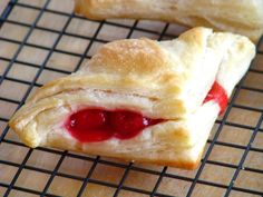 two pastries sitting on top of a cooling rack next to each other with jelly in them