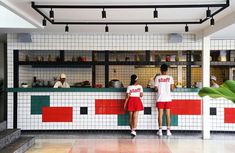 two people standing at the counter in a restaurant