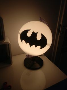 a lamp that is sitting on top of a table with a batman symbol on it