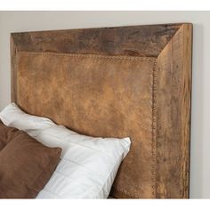 the headboard is made from an old piece of wood and has white pillows on it