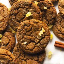 several cookies and cinnamon sticks on a white surface