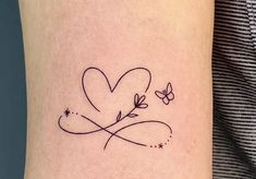 a small tattoo on the arm of a woman's leg with butterflies flying around it