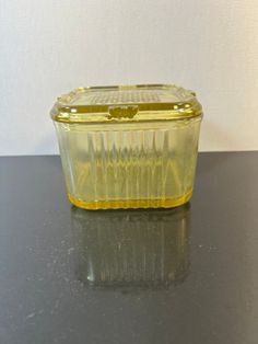 a yellow plastic container sitting on top of a table