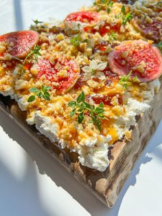 a close up of a pizza on a wooden board with cheese and tomato toppings