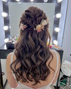 the back of a woman's head with long hair in front of a mirror