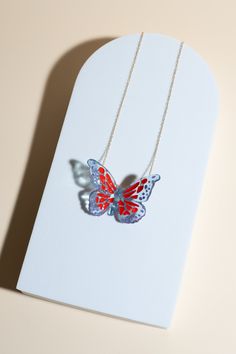 Based in: USAThis captivating piece is not just jewelry; it's a statement of individuality and elegance.Imagine a delicate butterfly, seemingly suspended in mid-flight, its wings adorned with mesmerizing red specks and intricate purple details. Each detail is meticulously crafted to capture the essence of grace and allure. This necklace is more than just an accessory; it's a reflection of your unique style and appreciation for sustainable craftsmanship. Wear it proudly to elevate any outfit, whether it's a casual ensemble or formal attire, and let it be a conversation starter wherever you go. Make a statement with this one-of-a-kind necklace! Details Made in: Broward, Florida Dimensions: 1.5" in. x 2" in. Chain length: 18" Weight: 0.1 oz. Metal: gold-plated chain Material: soy-based resin Red Butterfly Charm Necklace, Butterfly Charm Necklace For Party, Red Butterfly Necklace For Gift, Red Butterfly-shaped Jewelry Gift, Red Butterfly Jewelry For Gift, 3d Technology, Delicate Butterfly, Purple Details, Butterfly Necklace