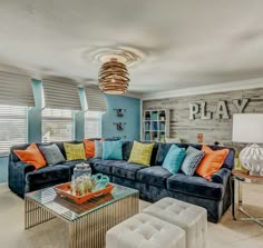 a living room with blue couches and orange pillows