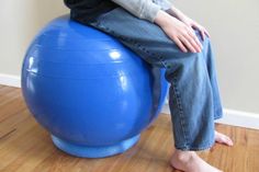 a person sitting on top of a blue exercise ball