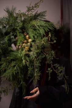 a woman holding a bunch of green plants in her hands