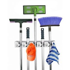 three brooms, two mop heads and one cleaning brush hanging on a rack