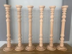 four wooden candlesticks lined up on a table