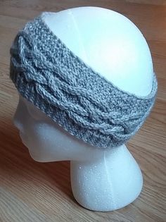 a white mannequin head with a gray knitted hat on top of it