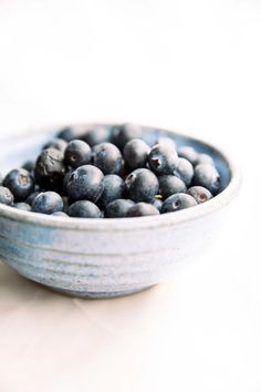 blueberries in a bowl on a white table