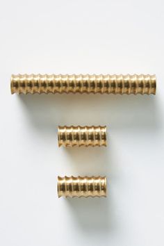 three brass screws on a white background