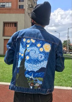 a man wearing a jean jacket with the starry night painting on it's back