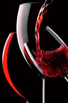 red wine being poured into a glass on a black and white background with an orange ring around it