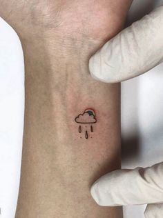 a person with a small tattoo on their left arm and the sky is raining behind them