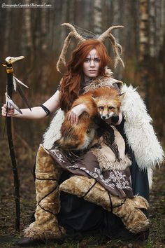 a woman dressed as a demon holding a fox