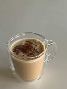 a glass mug filled with liquid on top of a table