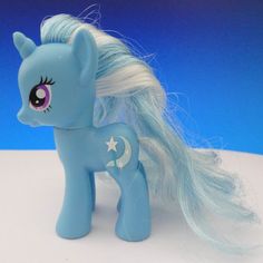 a blue pony with long white hair and stars on it's tail is standing in front of a blue background