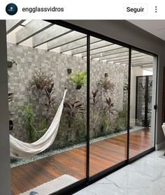 a white hammock hanging from the side of a glass wall