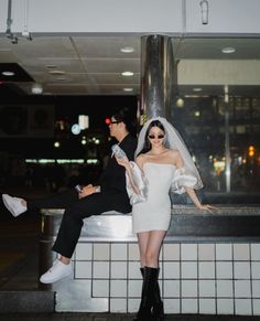 a man and woman posing for a photo in front of a building