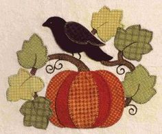 a black bird sitting on top of a pumpkin next to leaves and acorns