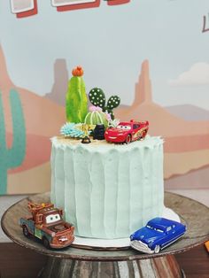 a birthday cake with cars and cactus on top