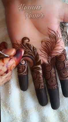 someone is doing henna tattoos on their hands