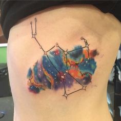 a woman's lower back with an abstract tattoo design on her ribs and the constellation sign