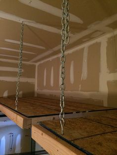 an unfinished room with metal chains hanging from the ceiling