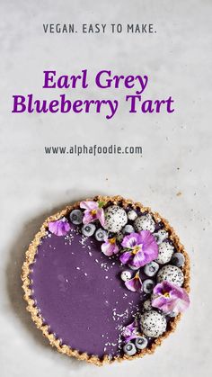 a blueberry tart is shown with flowers on top and the text vegan easy to make