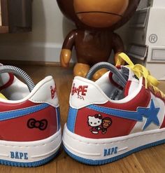 a pair of red, white and blue sneakers with hello kitty on the upper part