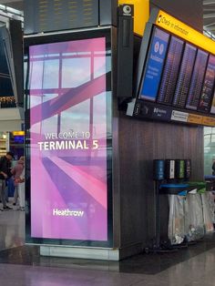 an airport terminal with people waiting for their luggage