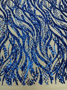 blue and white sequins on fabric with wavy lines in the center, as well as an intricate design