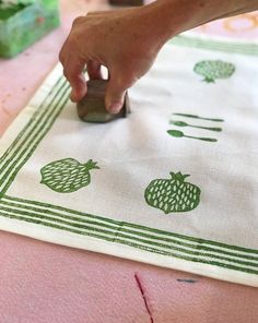 a person is using a stamper on a piece of cloth