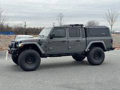 a gray jeep parked in a parking lot