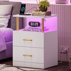 an alarm clock is on top of a night stand