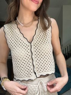 a woman is wearing a white top and has her hands in her pockets as she looks at the camera