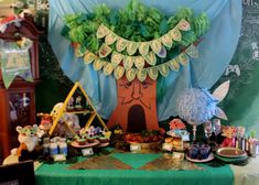 a table topped with lots of food and decor on top of a green table cloth