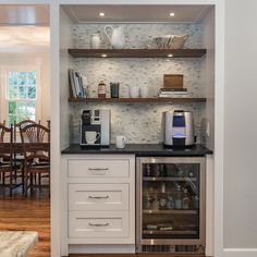 a kitchen with white cabinets and black counter tops, an oven and coffee maker in the corner