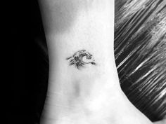 a woman's foot with a small wave tattoo on the left side of her ankle