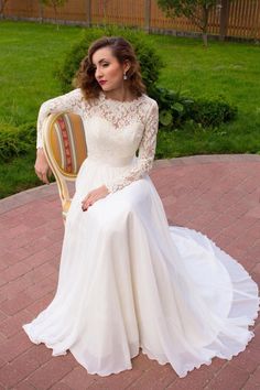 a woman in a white dress sitting on a chair