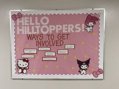 a hello kitty bulletin board hanging on the wall in an office cubicle with pink and white writing