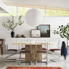 a dining room table with chairs and a rug on the floor in front of it